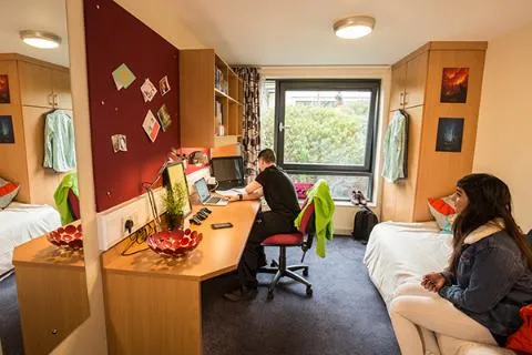 A student sat at his desk in a bedroom in All Saints Court.