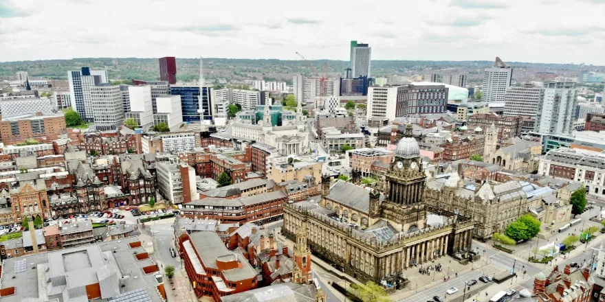 Aerial view of Leeds city centre including Town Hall and brick buildings.