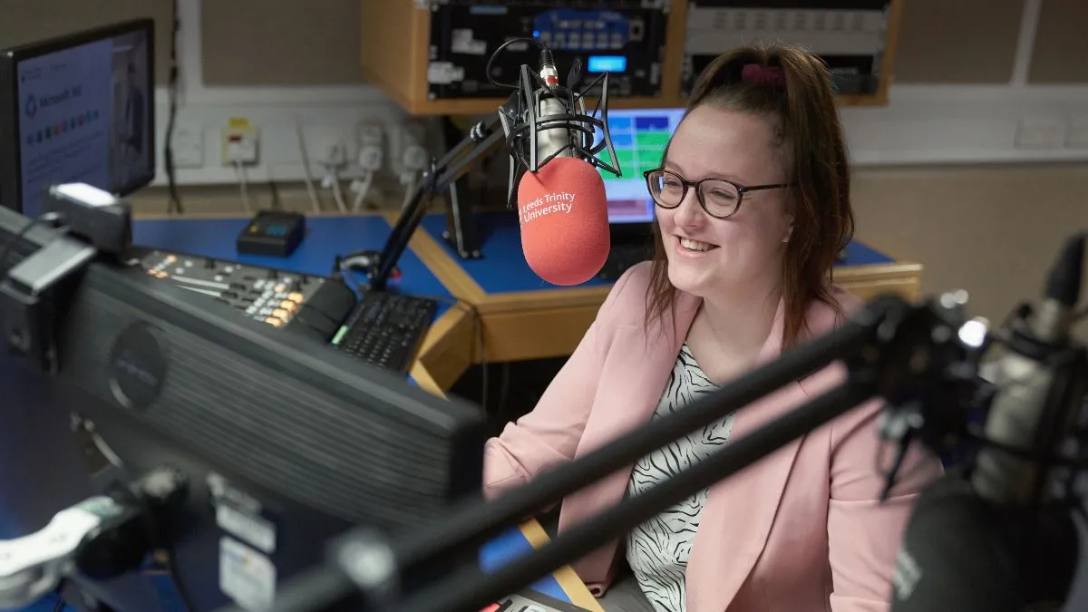A student sits in a radio studio.