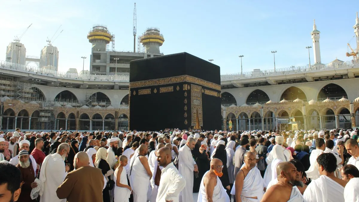 A crowd of people stood in front of the Kaaba, a stone building at the centre of Mecca.