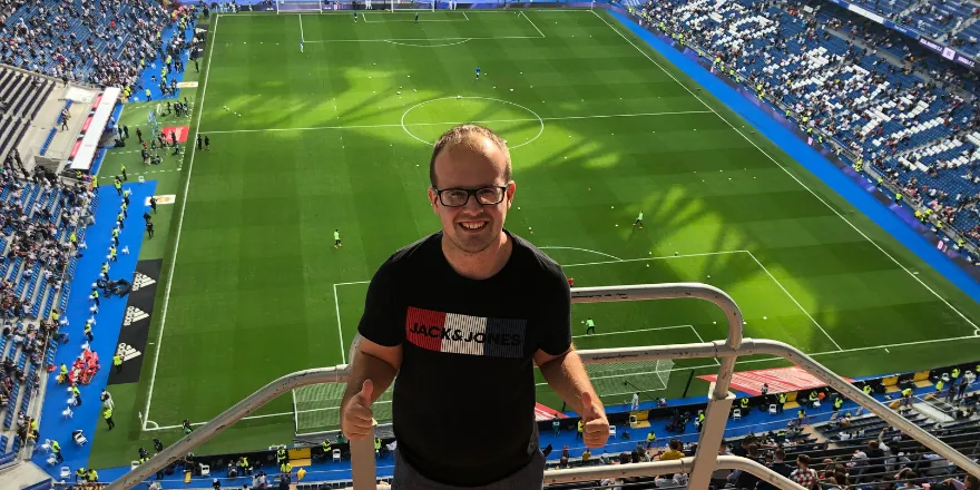 Student stood overlooking football stadium.