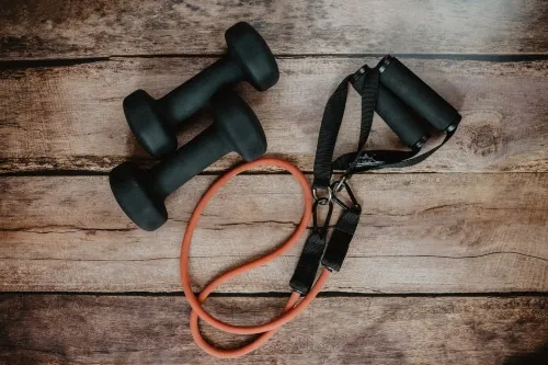 Gym equipment including dumbbells and skipping rope.