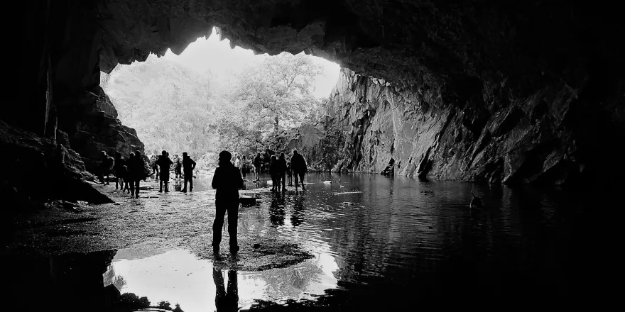 Black and white image of people in cave.