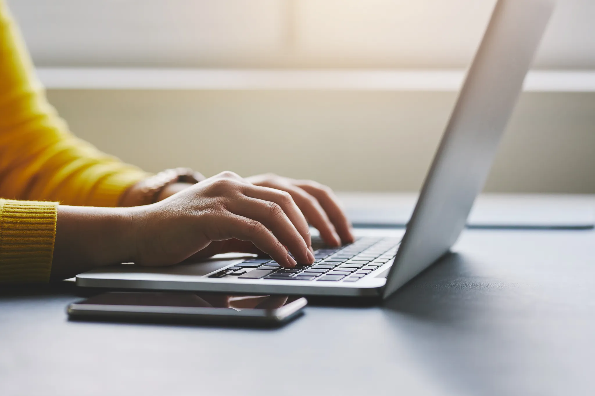 Close up photo of female hands typing on laptop.