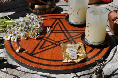 Pentacle surrounded by various artefacts in use for a pagan ritual blessing.