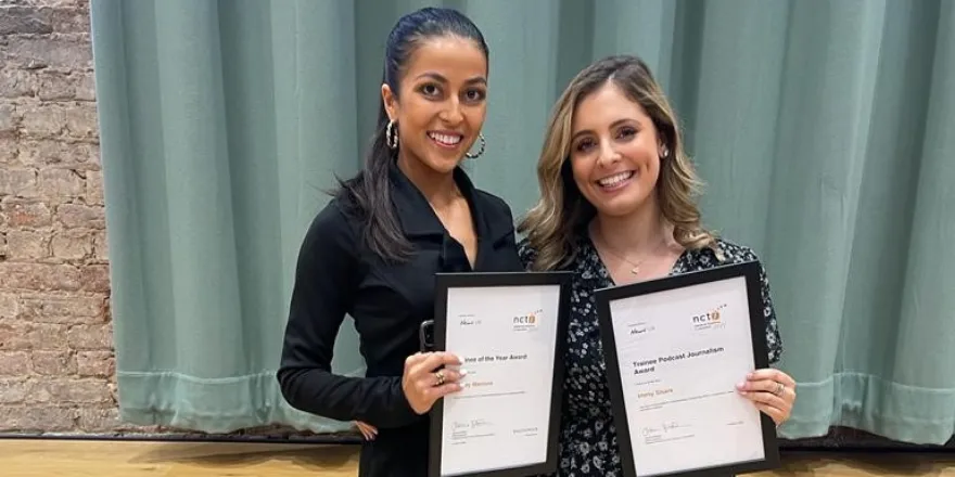 Female with dark hair tied back stands next to blonde female both holding certificates.