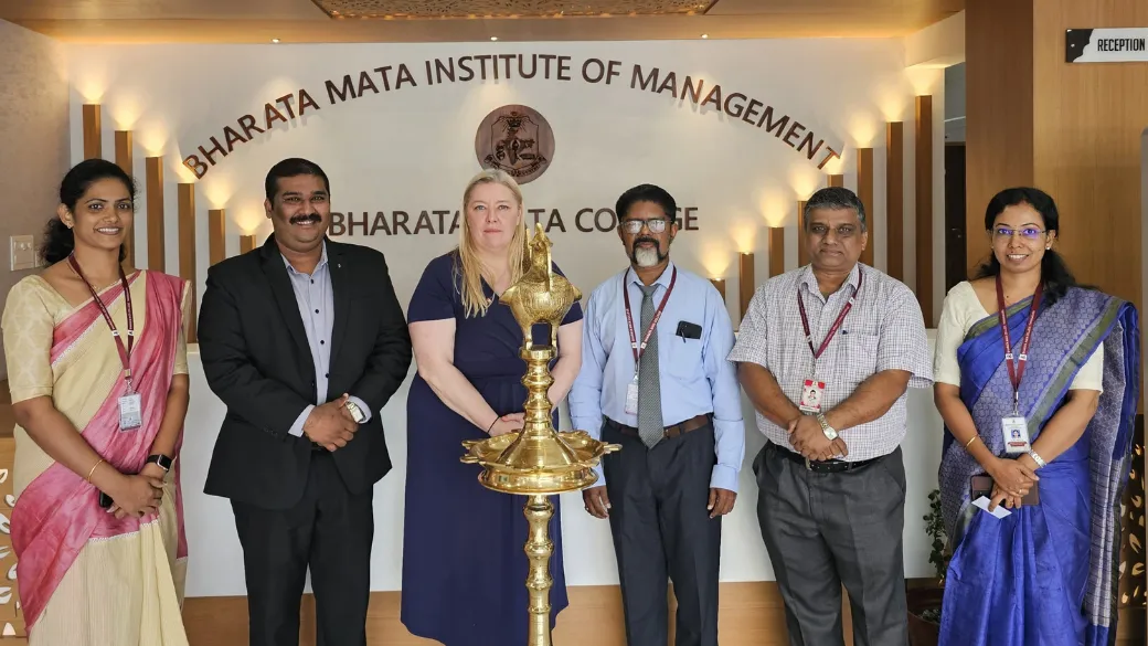 A group of six people posing at the Bharata Mata Institute of Management in India..