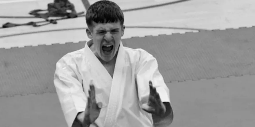 Black and white image of male athlete playing karate.