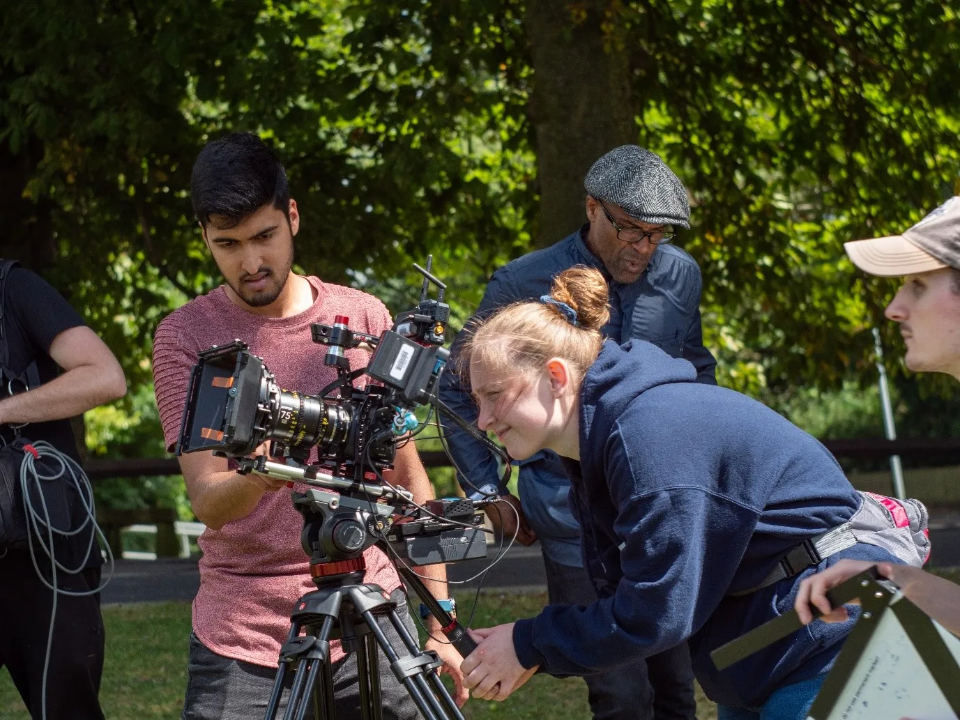 4 students and staff on set filming.