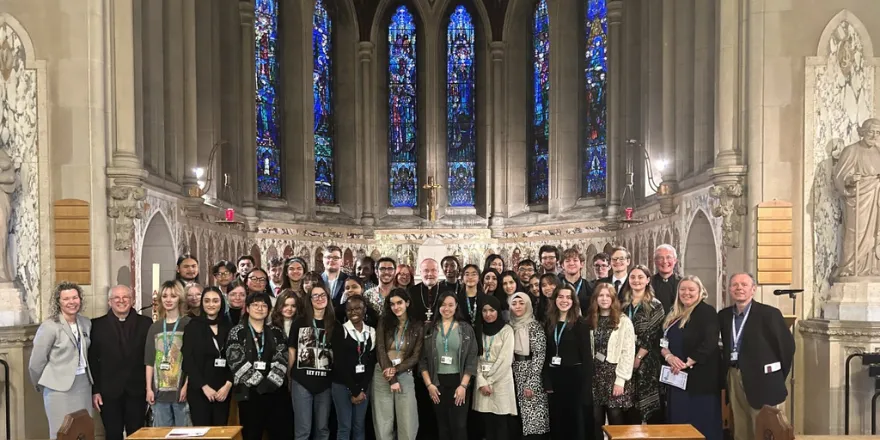 students and staff standing together in a chapel for a photograph.