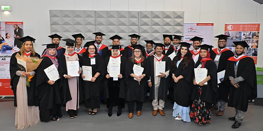A group of students in caps and gowns holding their degrees..