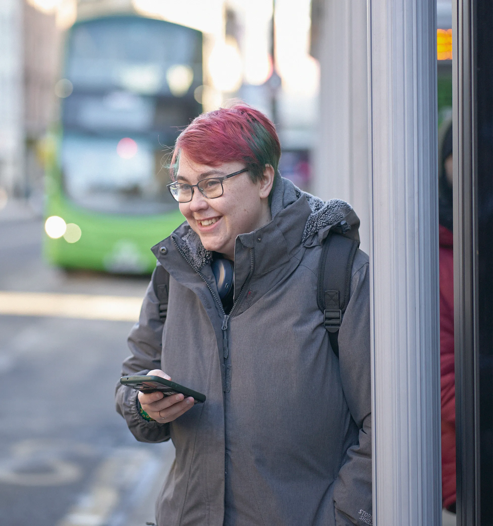 Student waits at bus stop in Leeds City Centre.